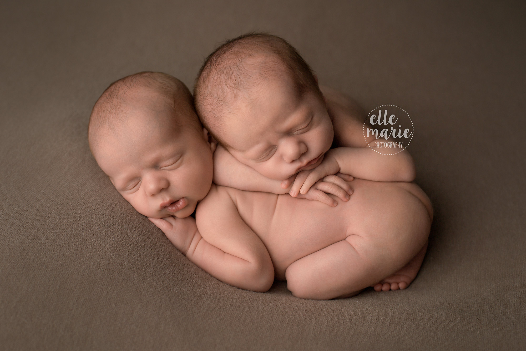 newborn baby boy twins laying on each other