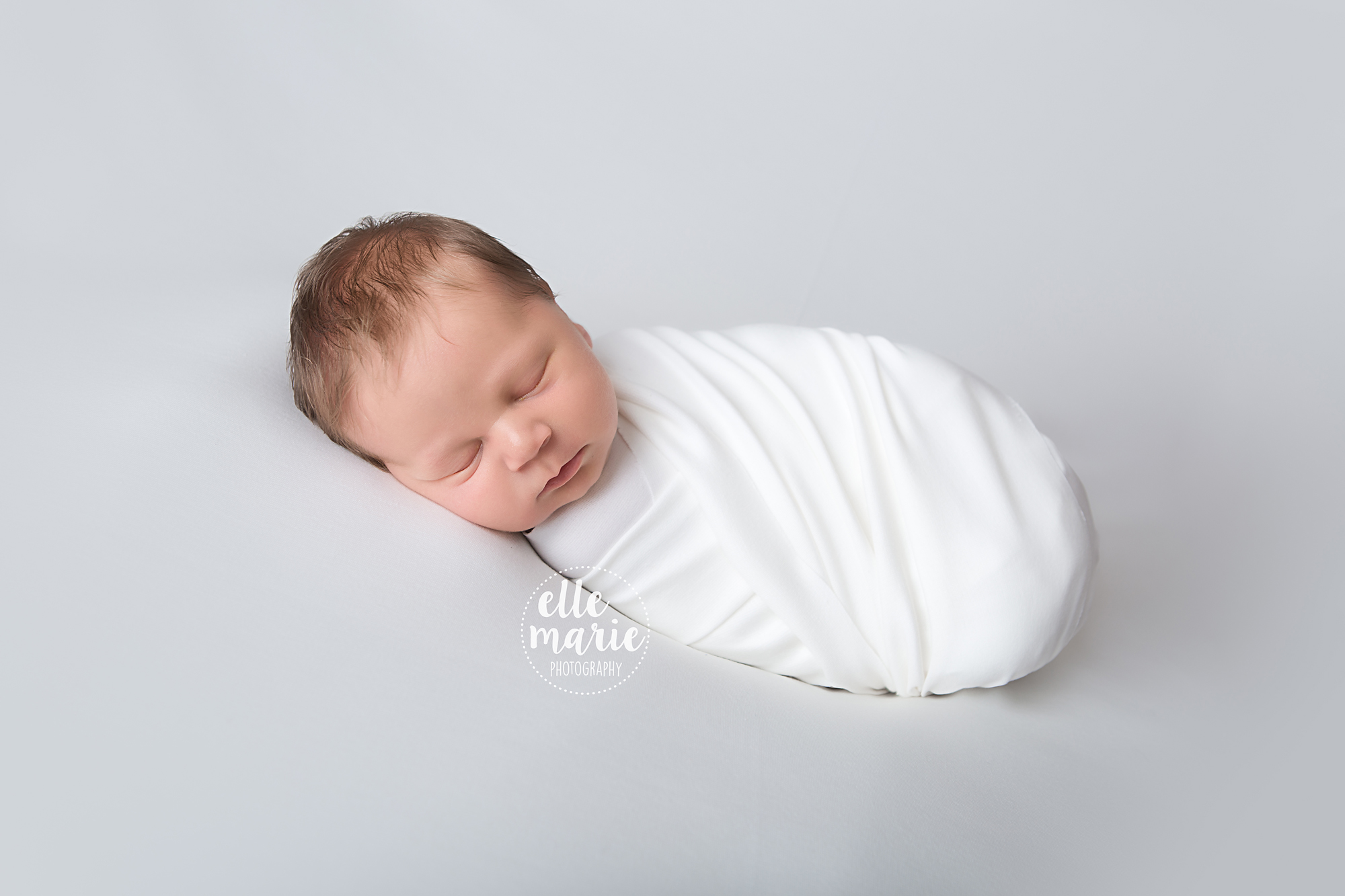 newborn wrapped in white