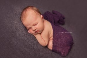 newborn with purple wrap