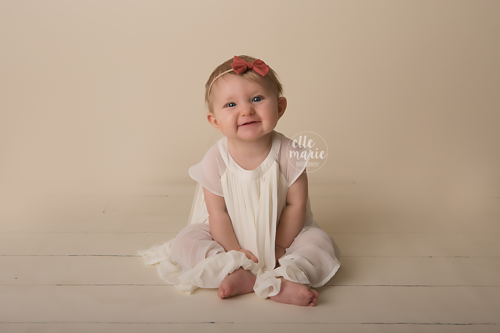 6 month old baby sitting up and smiling at camera