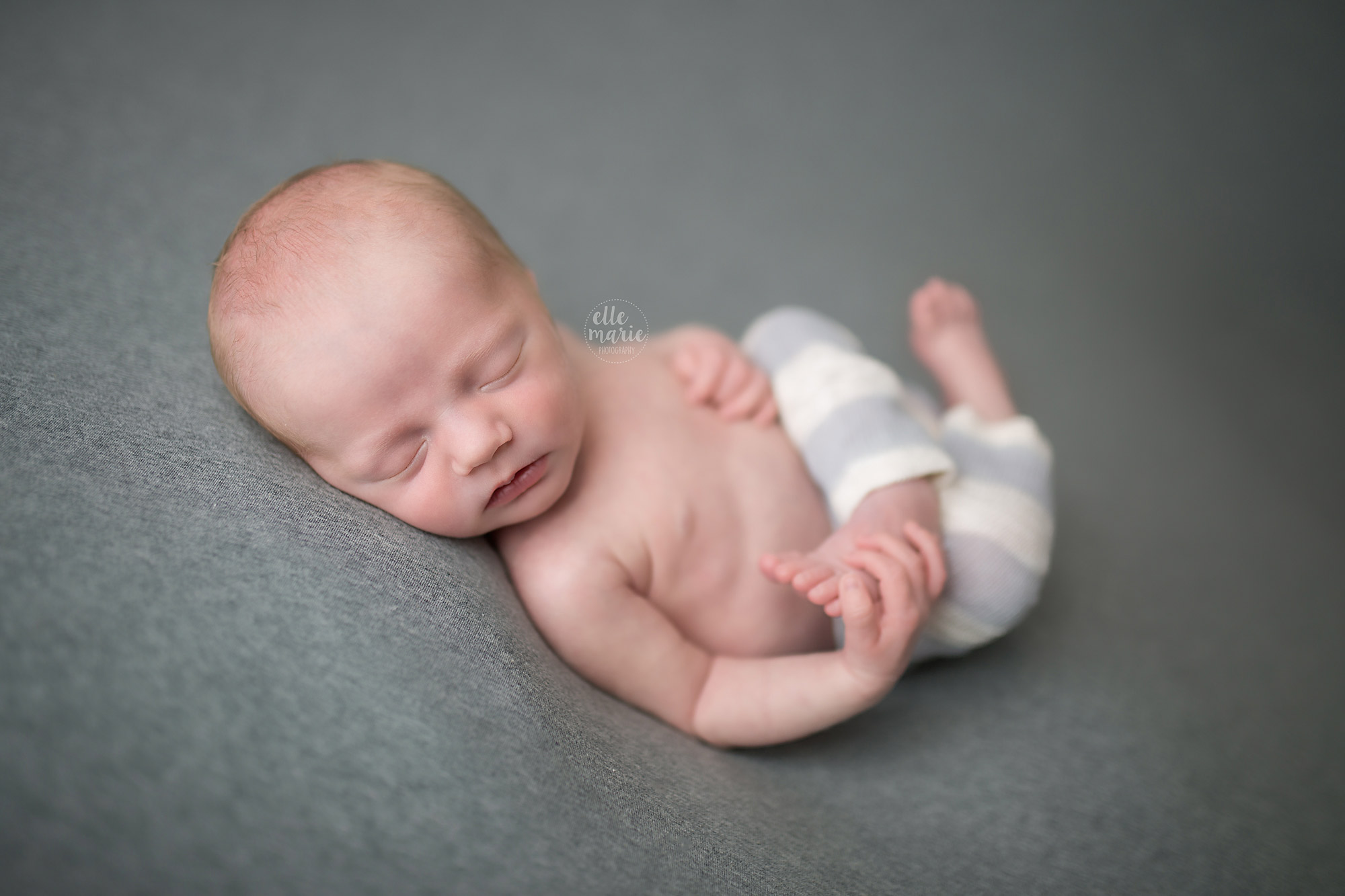 newborn baby boy holding his foot