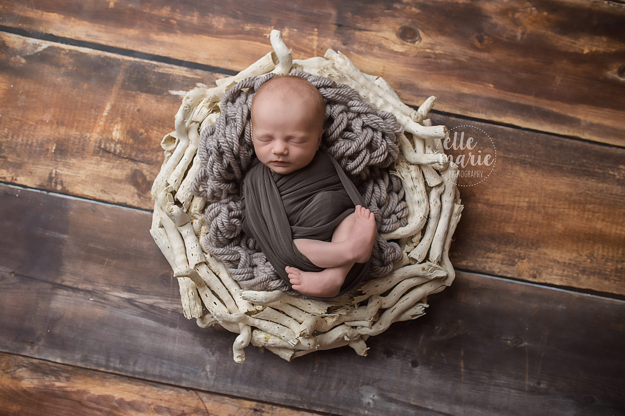 newborn baby wrapped on birch and wood