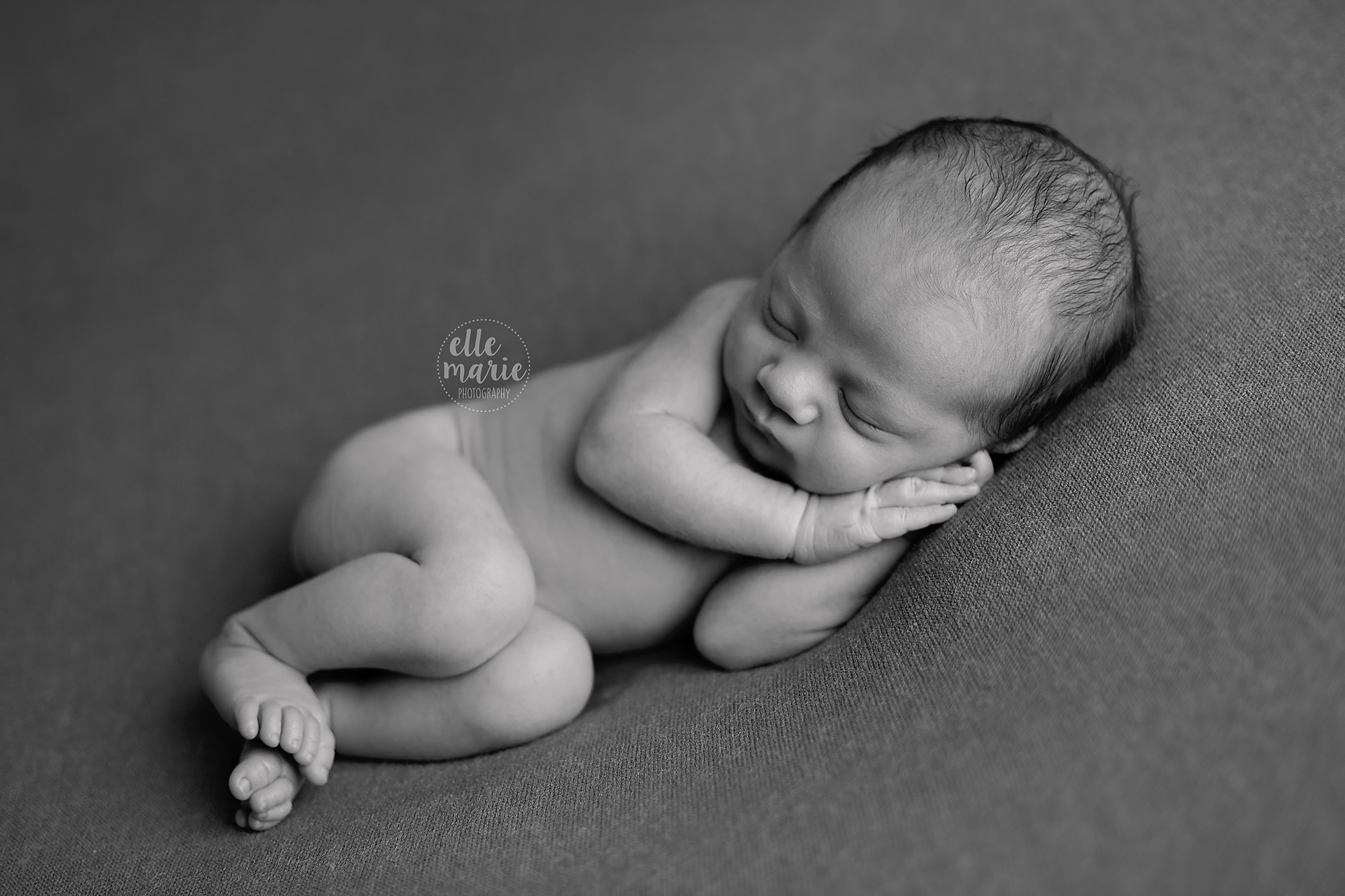 newborn boy laying on side, black and white