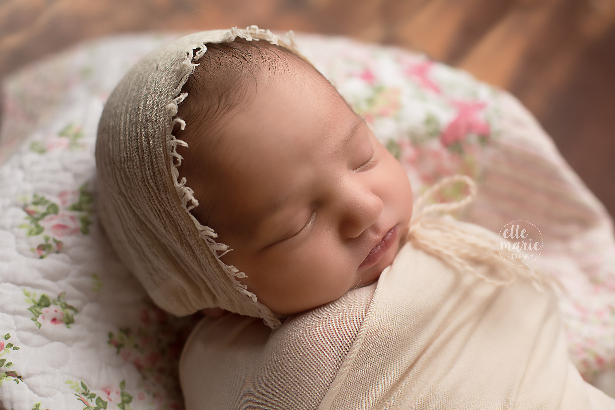 newborn baby girl in cream bonnet