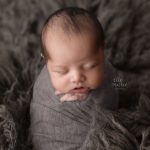 baby boy wrapped in grey