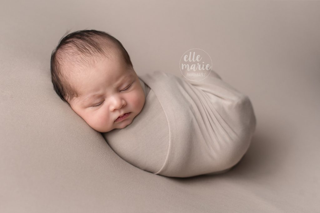 newborn wrapped in beige