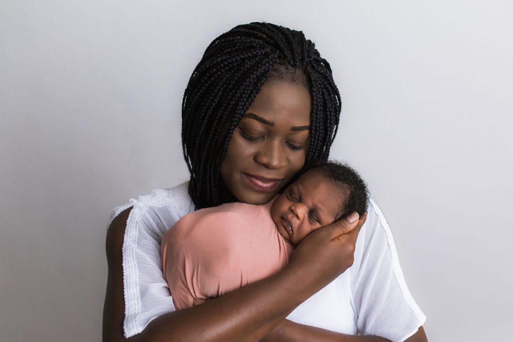 happy mom holds newborn daughter