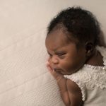 newborn baby girl on cream