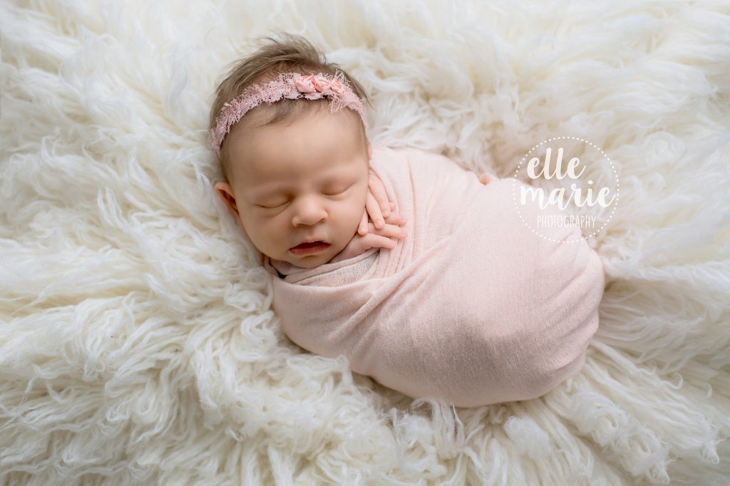 newborn baby girl wrapped in pink