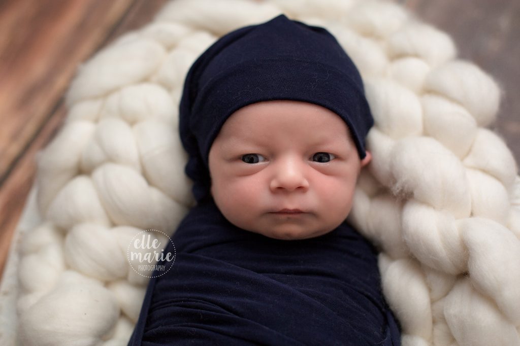 baby boy in navy looking at camera