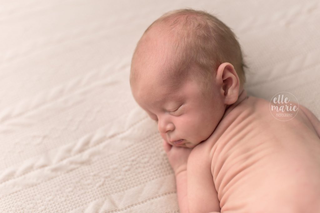 newborn baby boy laying on tummy showing side profile of face
