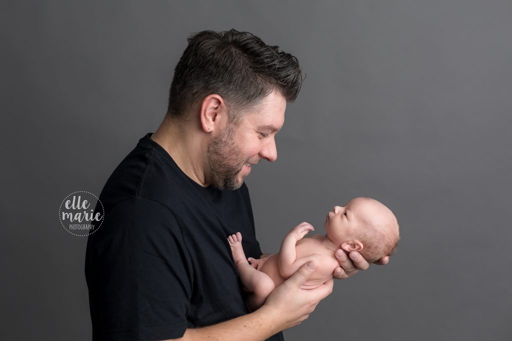 dad holding newborn baby noy