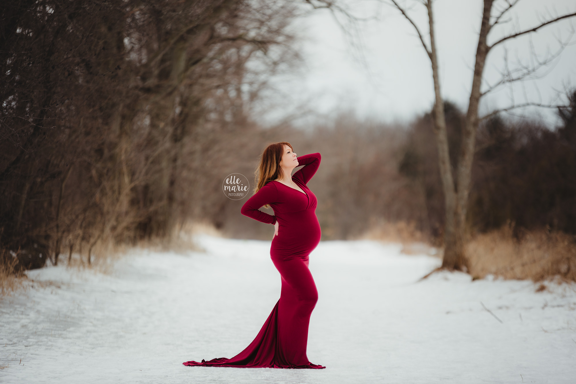 expecting mother in red gown in winter setting