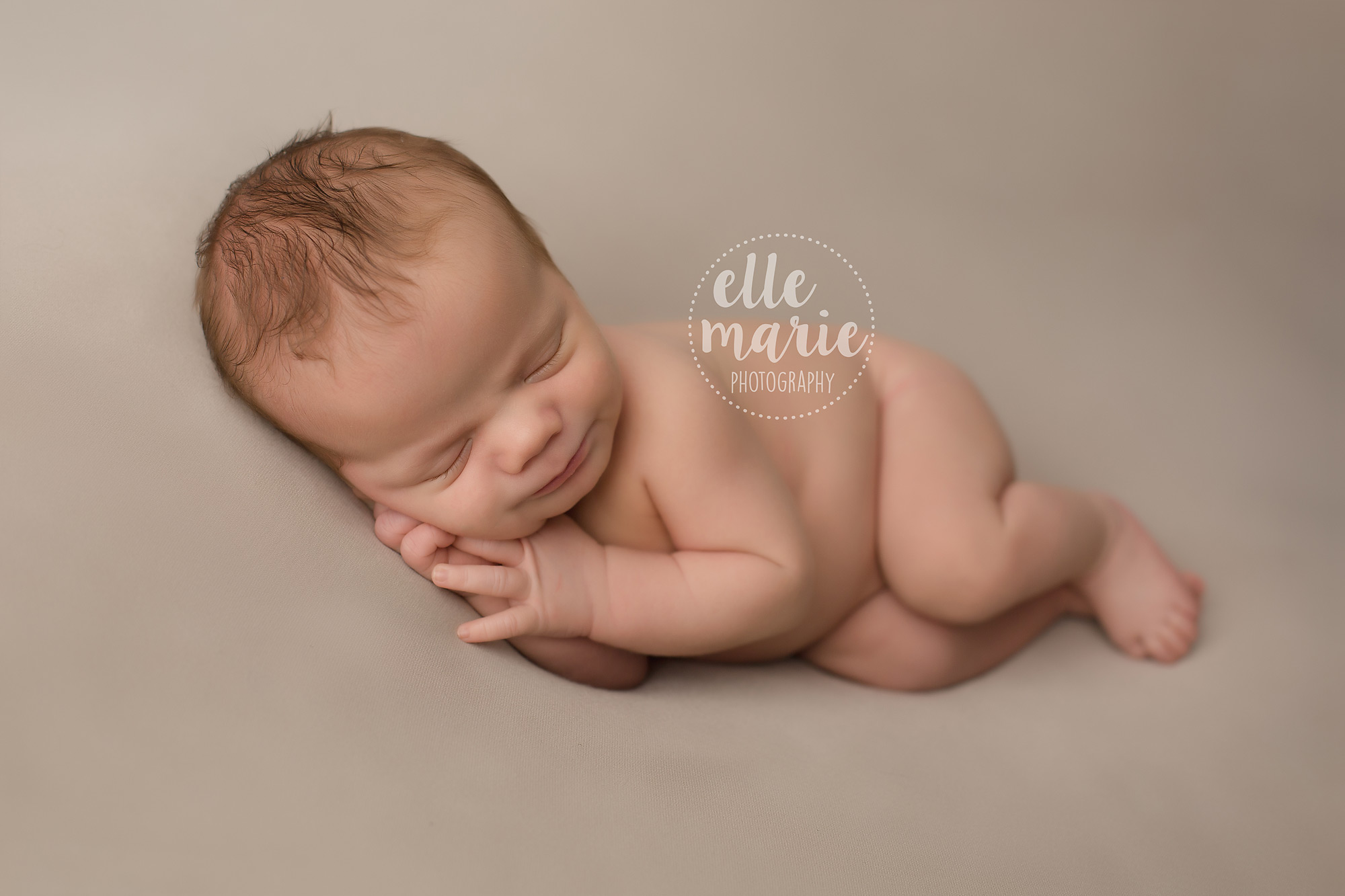 Newborn baby boy posed in side laying position