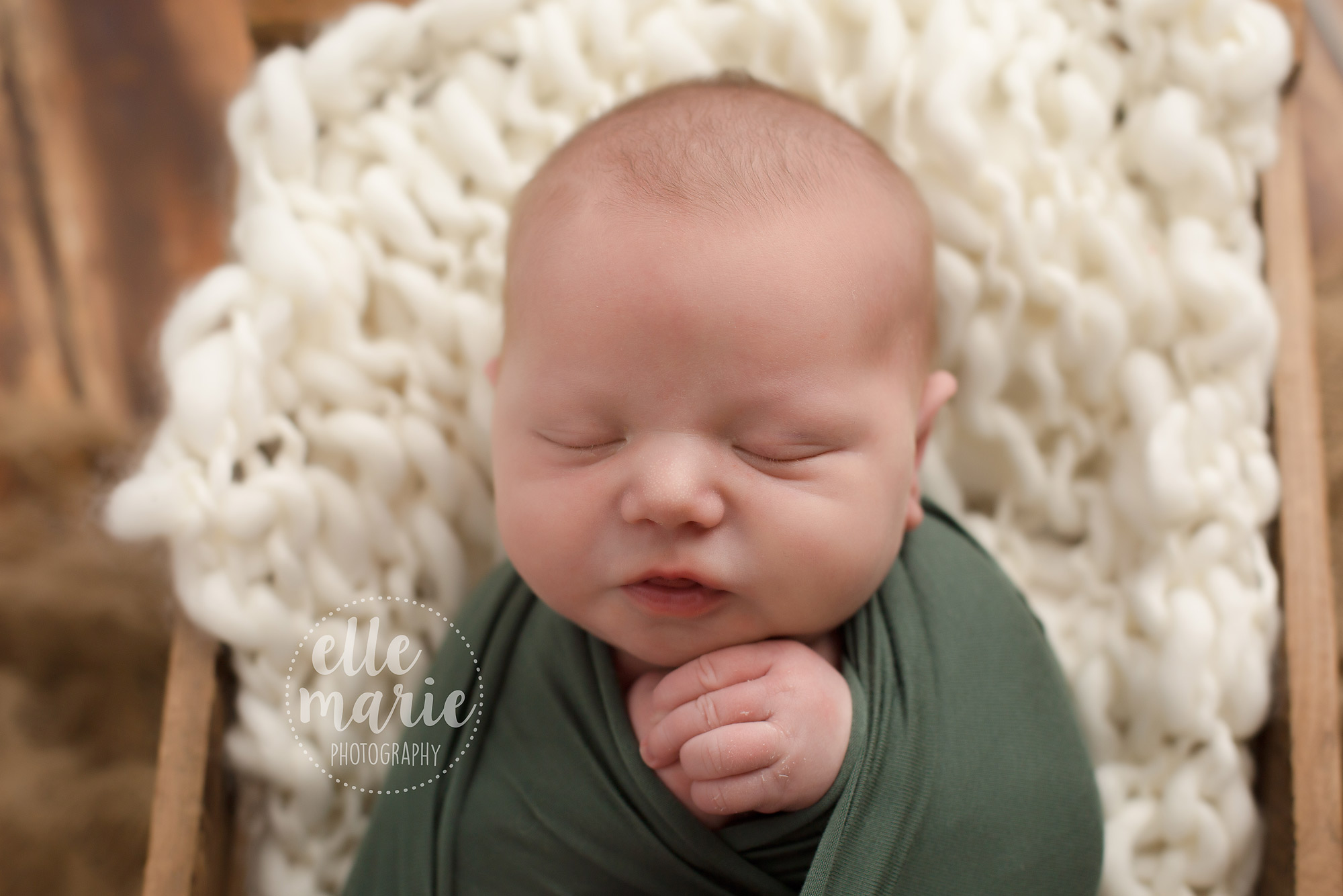 newborn baby boy wrapped in green