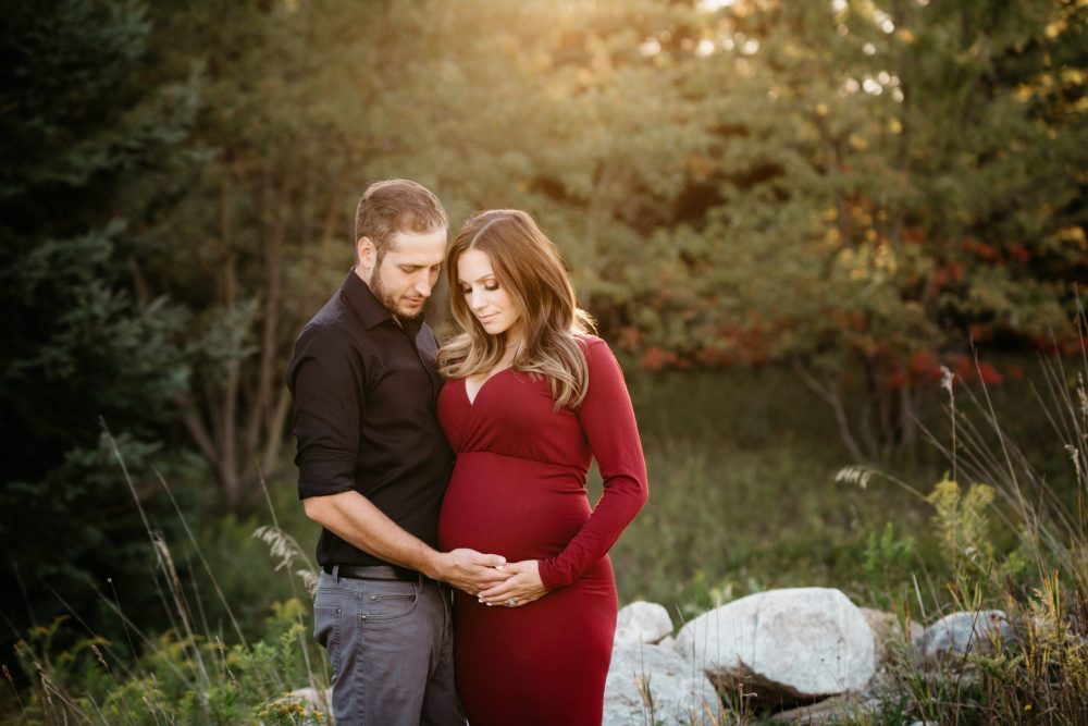 pregnant woman in red dress with husband