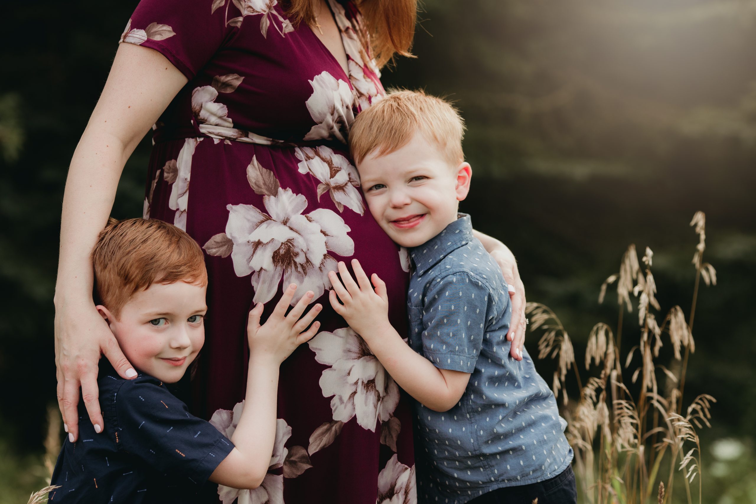 pregnant mom hugging two older siblings hugging her belly