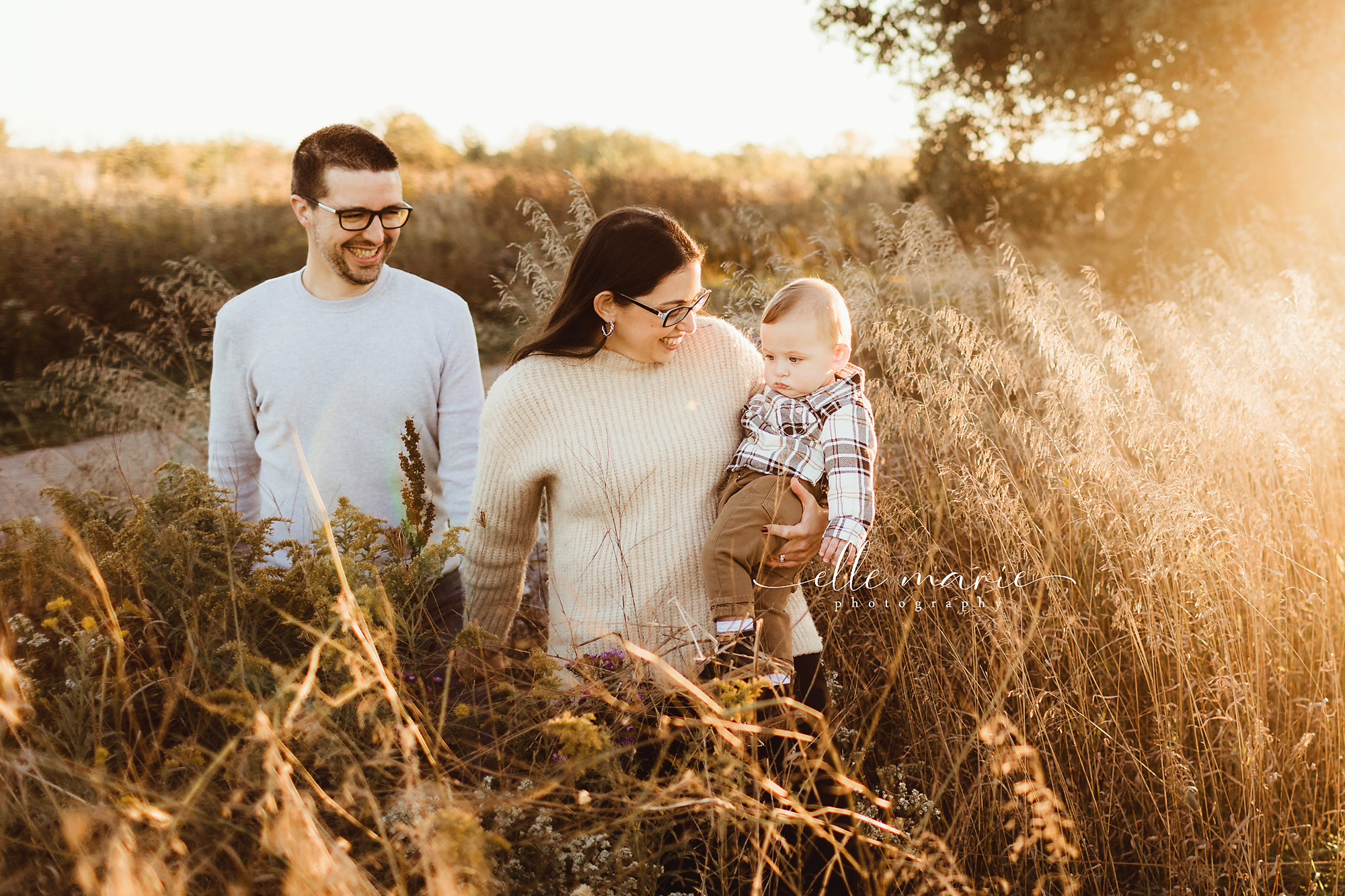 a family of three at golden hour walks on a path
