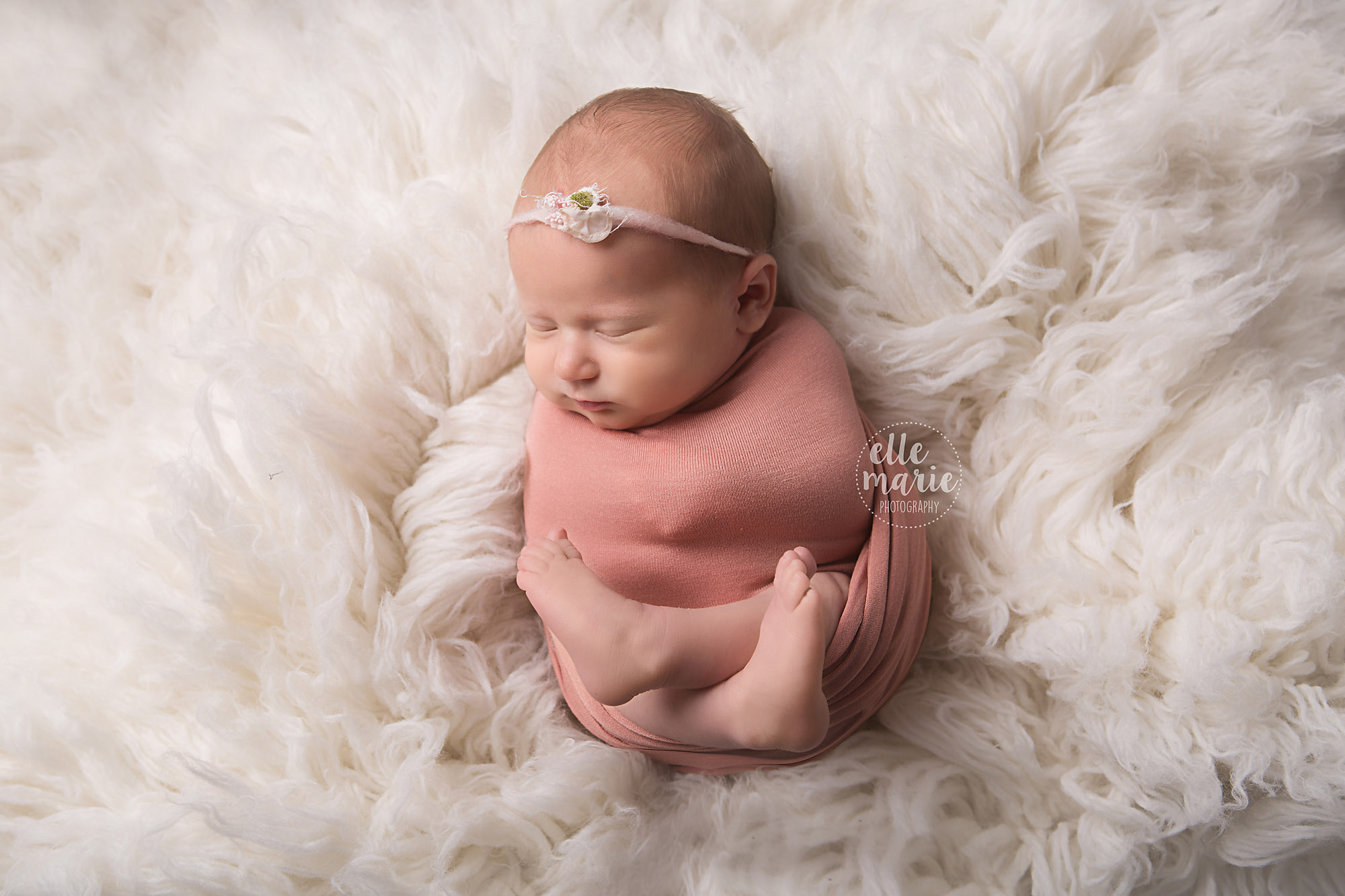 newborn girl in pink wrap