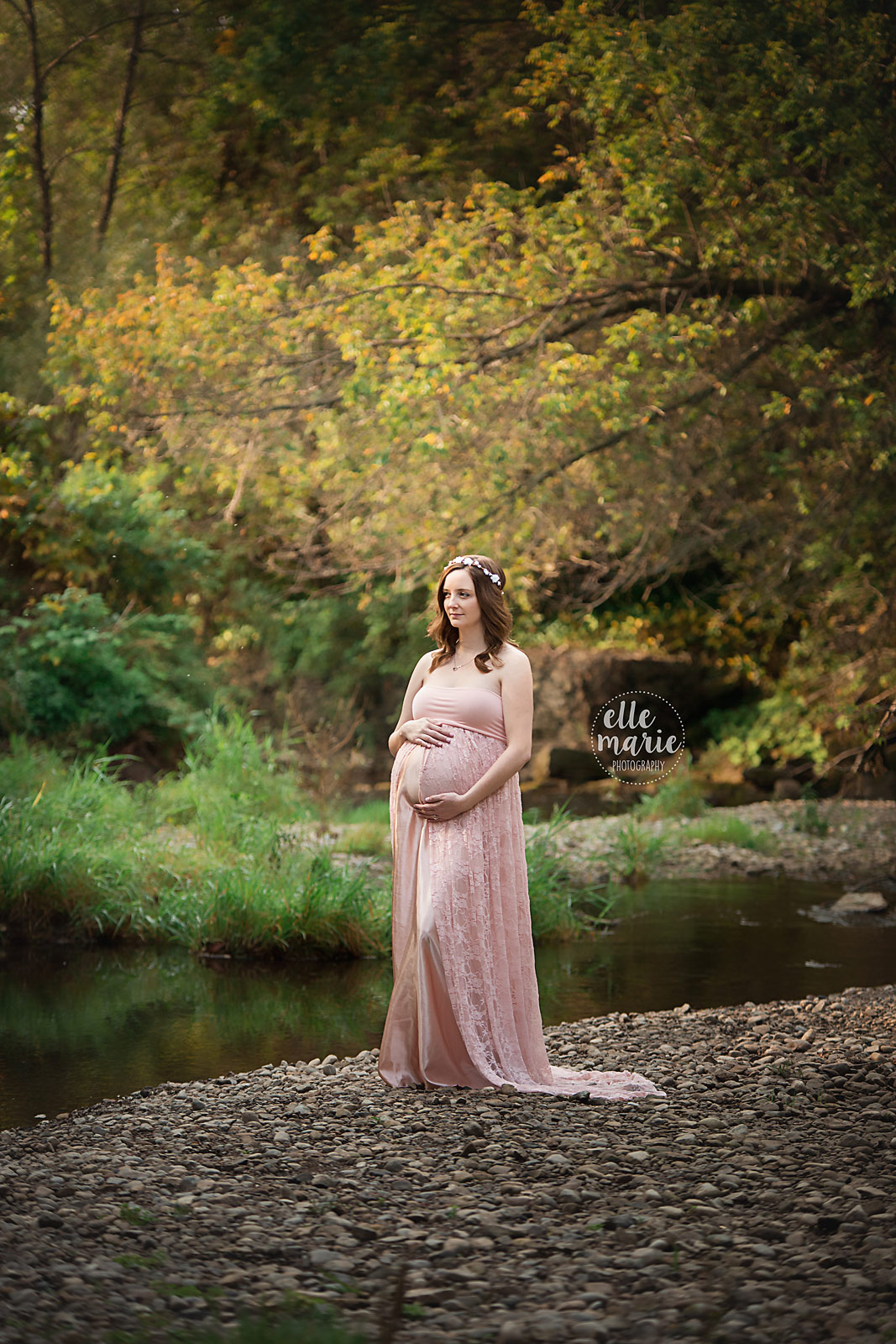 expecting mother wearing pink maternity dress looking at camera