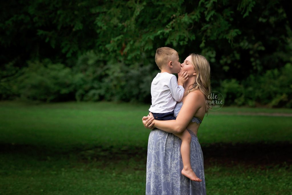 pregnant mom kisses toddler son