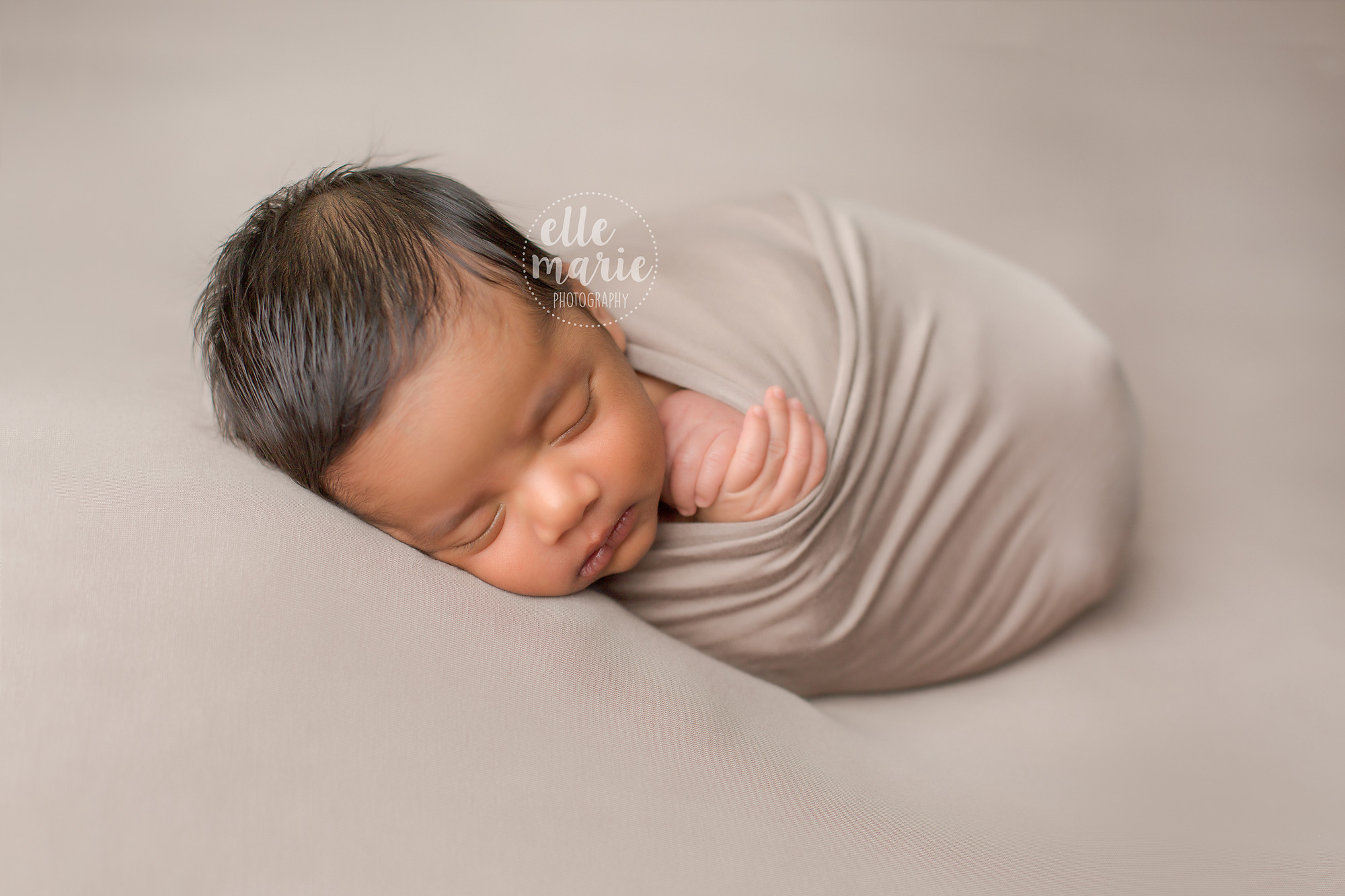baby boy swaddled in beige wrap