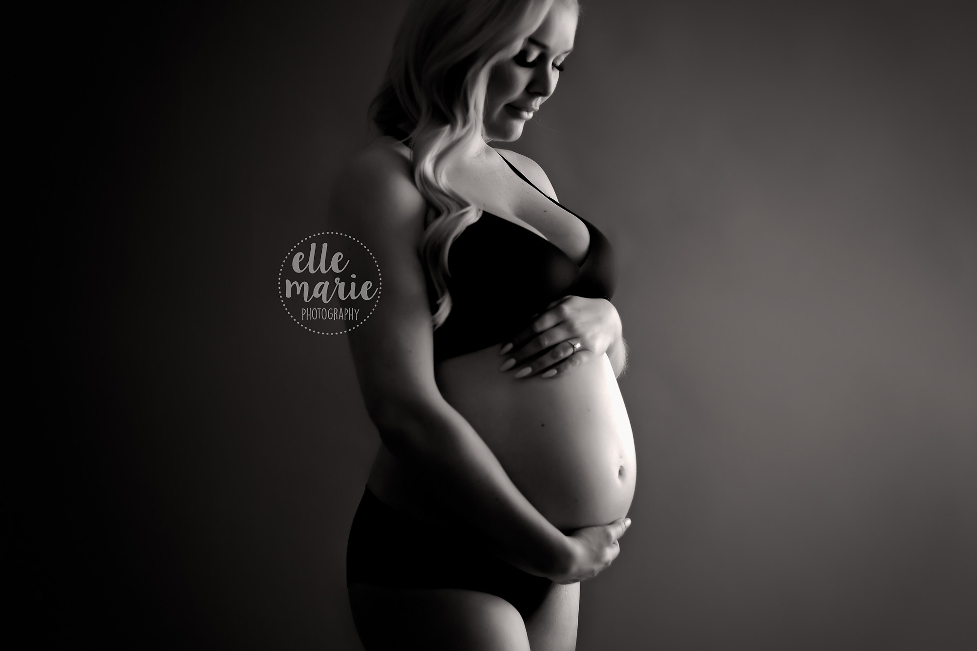 black and white of pregnant mother with focus on the belly