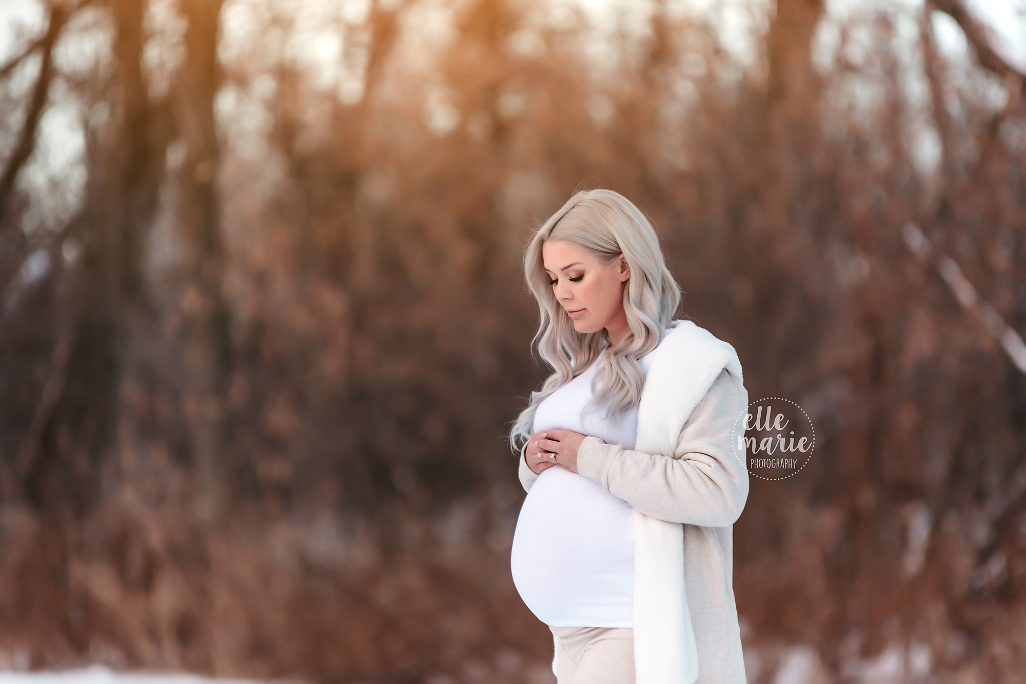 pregnant mother in the snow during golden hour