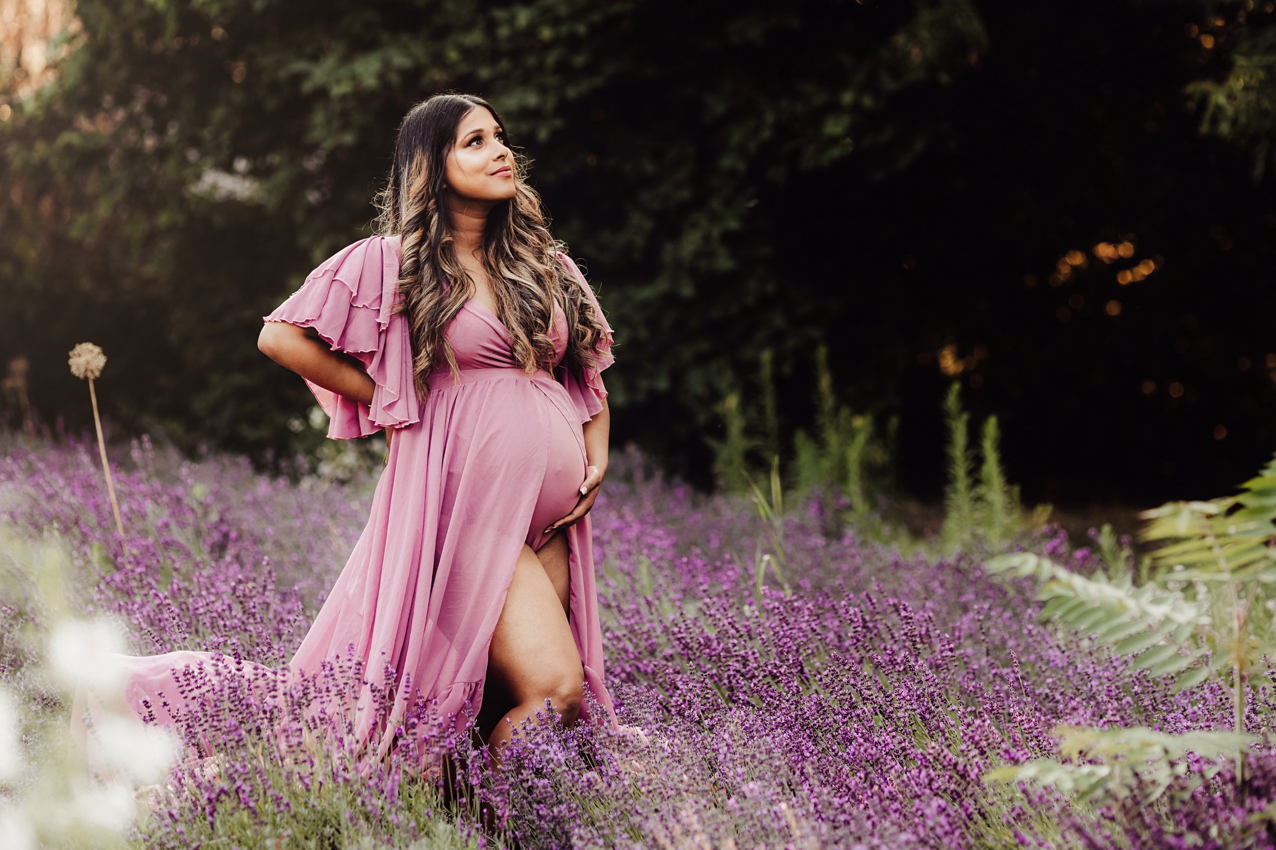 pregnant lady in lavender coloured gown standing in lavender