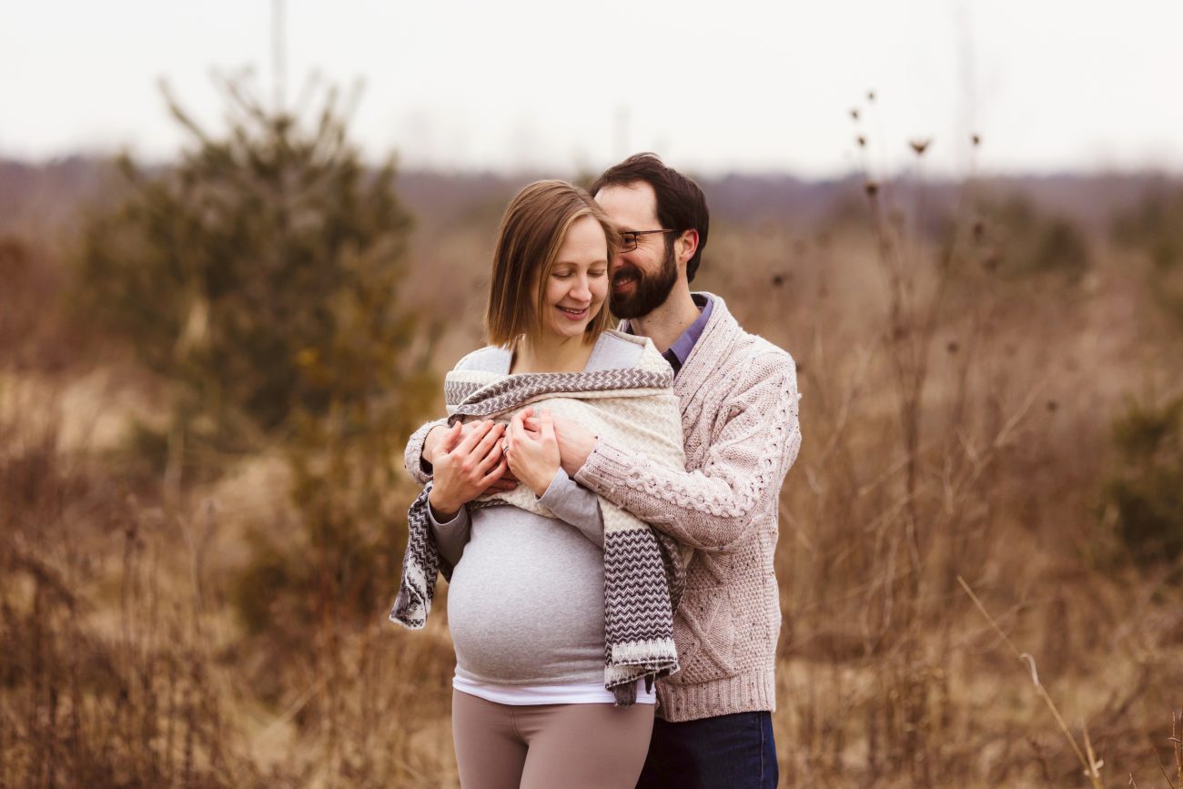 maternity couple snuggling in the winter