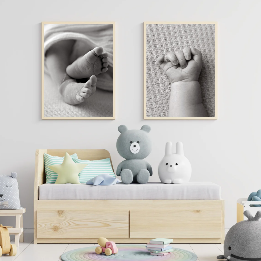 Baby furniture in a nursery with 2 framed images of baby hand and feet on the wall