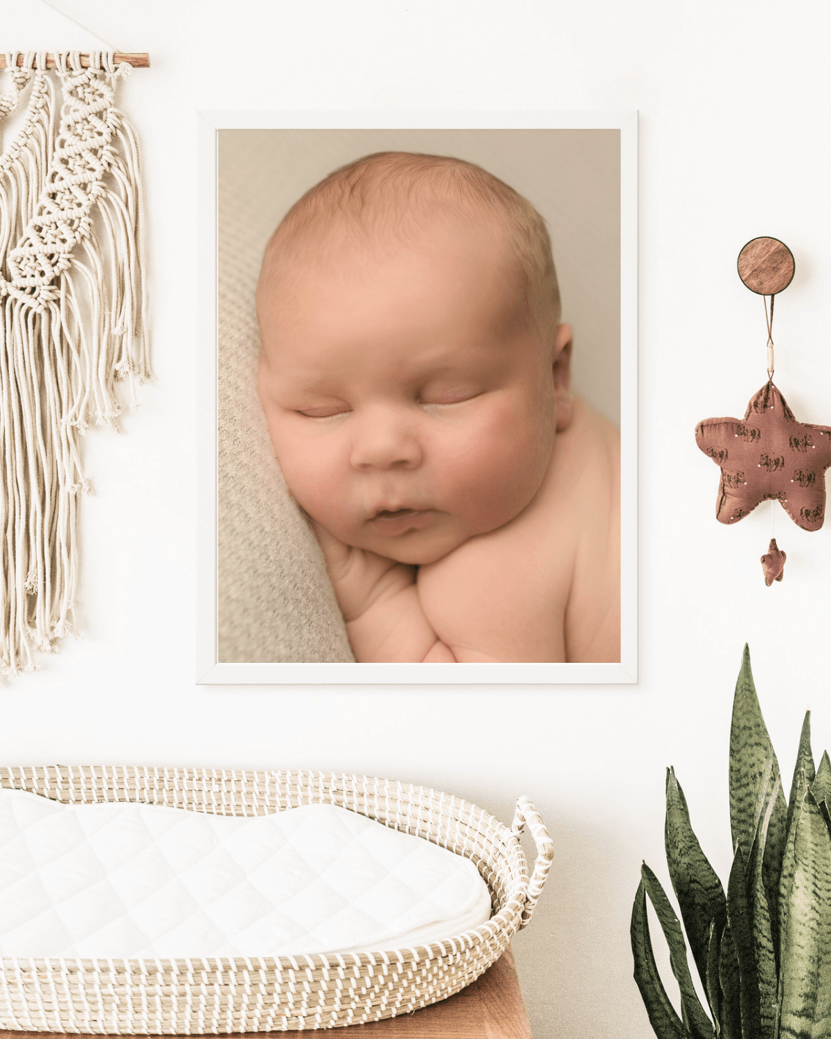 framed wall art of newborn baby hanging in nursery