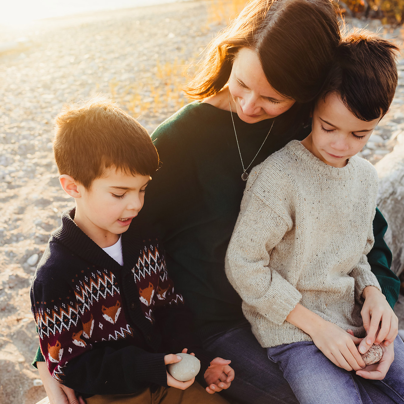 mom sitting at sunset with her family