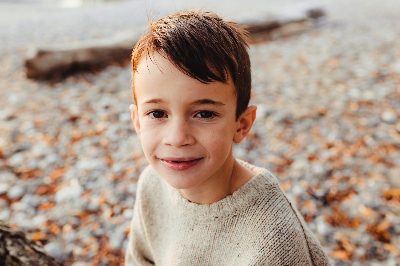 young boy sitting on whitby beach