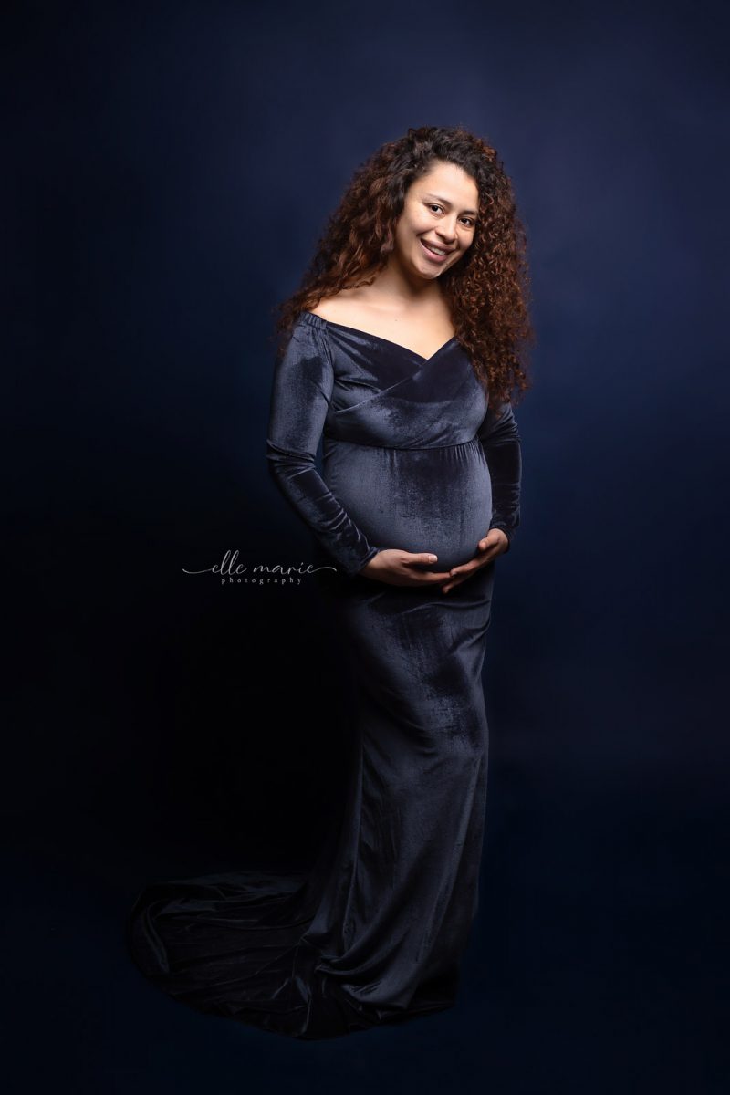 woman in blue velvet maternity gown