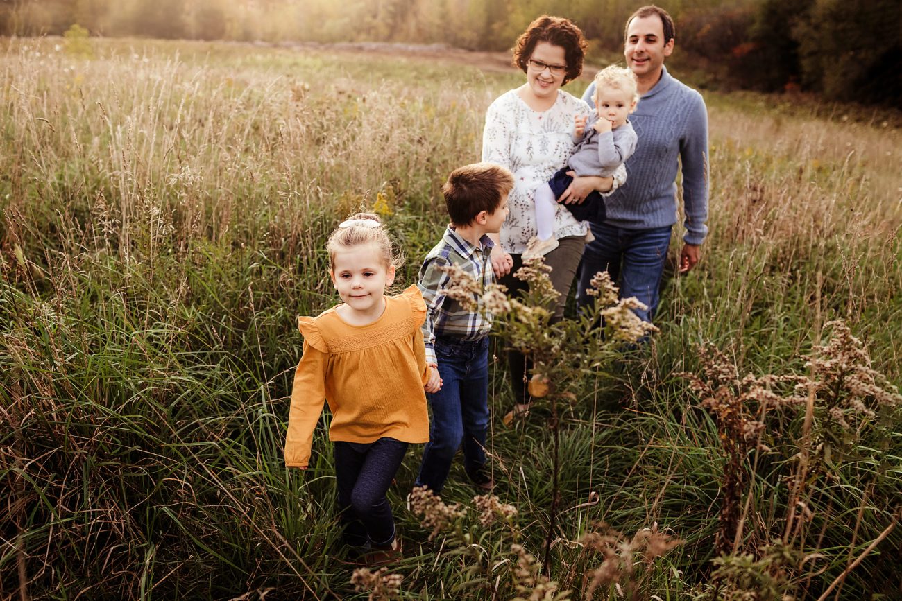 family walks through a field