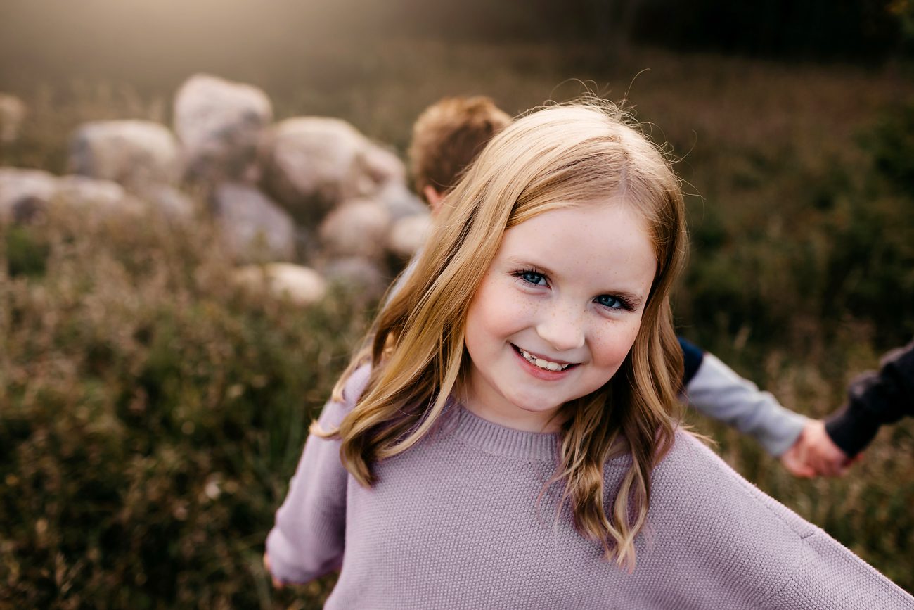 a young girl playing ring around the rosy with family